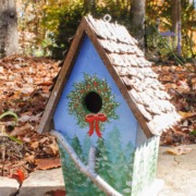 birdhouse with winter tree scene hand-painted, pine cone roof, and branch for perch