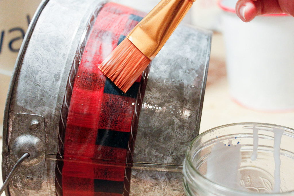 painting watered down glue onto pail