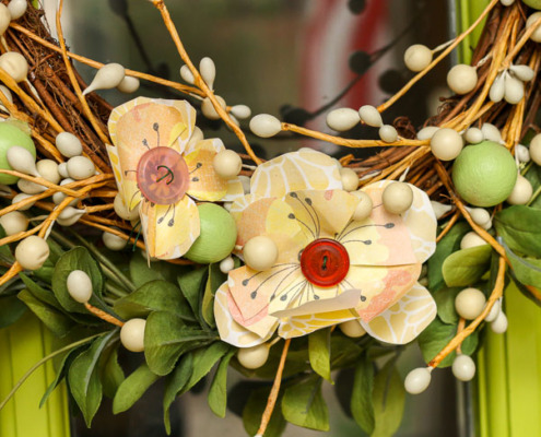 Close up two yellow scrapbook flowers on wreath