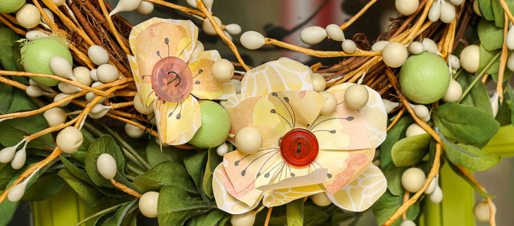 Close up two yellow scrapbook flowers on wreath
