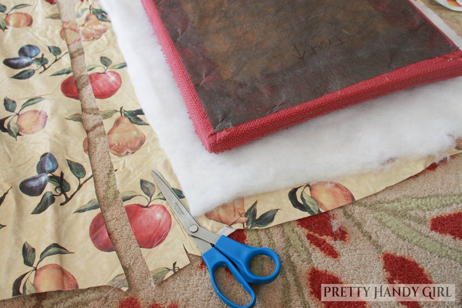 cut fabric, oil cloth, and batting to larger size than original cushion