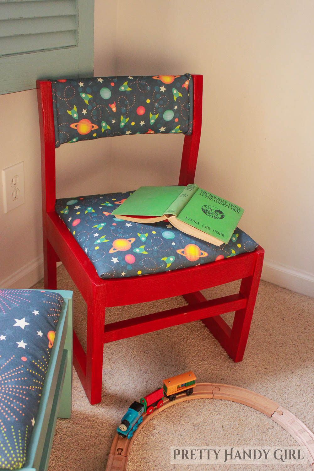 one red refurbished this end up style chair with red frame and space fabric