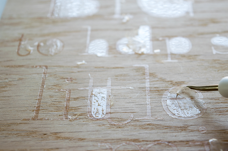 Remove any excess glue flakes from the stencil of the teacher sign.