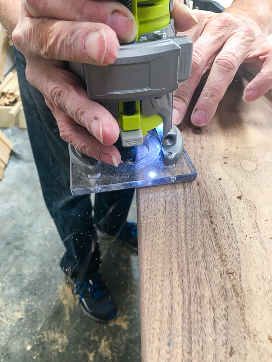 Round over the edges of the cheese board with a 1/8" roundover bit on the router.