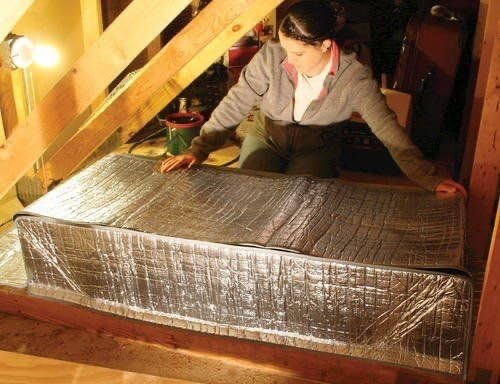 woman in attic-covering the attic opening with a foil box