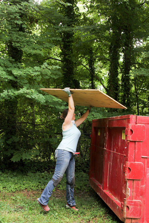Throwing Sheets into Dumpster