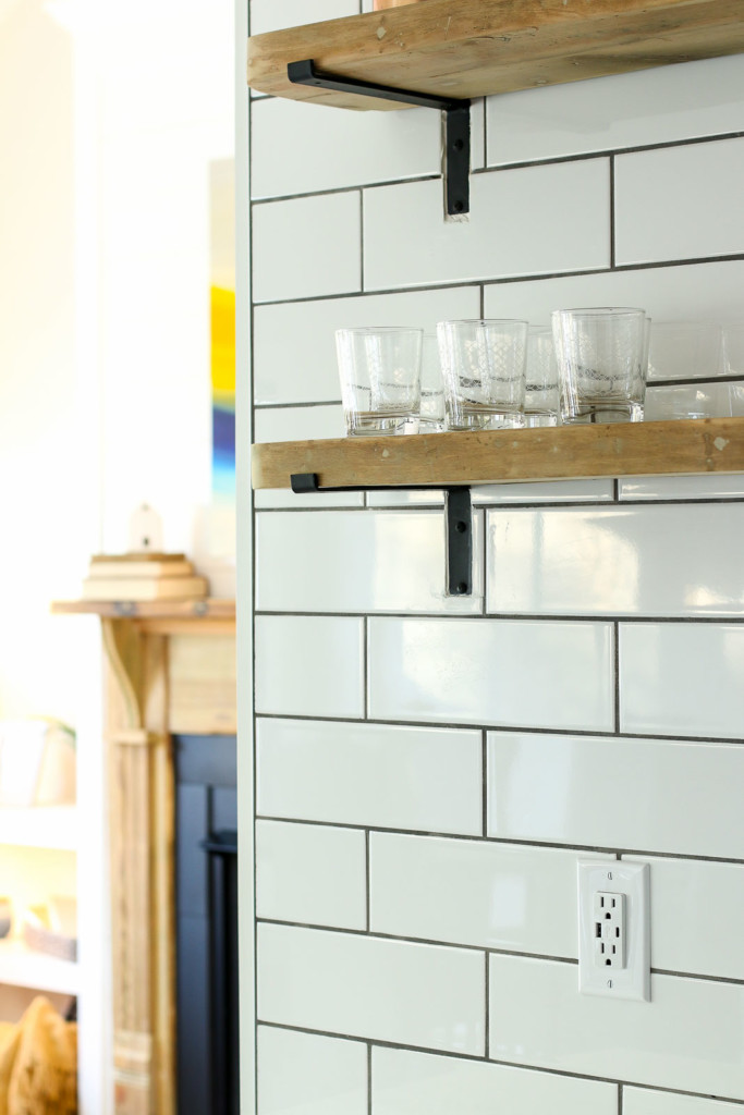 white usb charging outlet on white subway wall open shelving