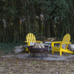 adirondack chairs around fire pit on old shed concrete pad