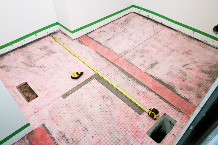 Installed uncoupling mats, finding center of room. Marking perpendicular lines.