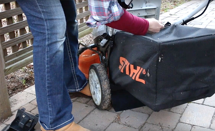 inserting grass collection bag onto mower