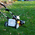 man pushing lawnmower shown from back