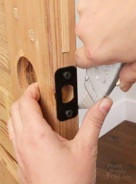 using utility knife to score around latch plate