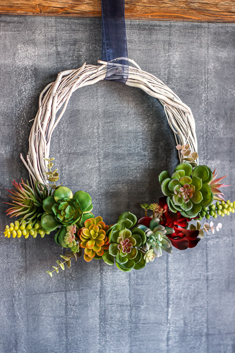 Finished DIY faux succulent wreath over chalkboard