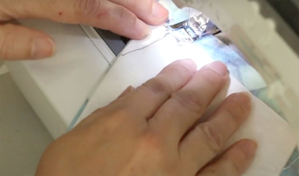 sewing chin dart on one mask and moving onto nose of a second one.