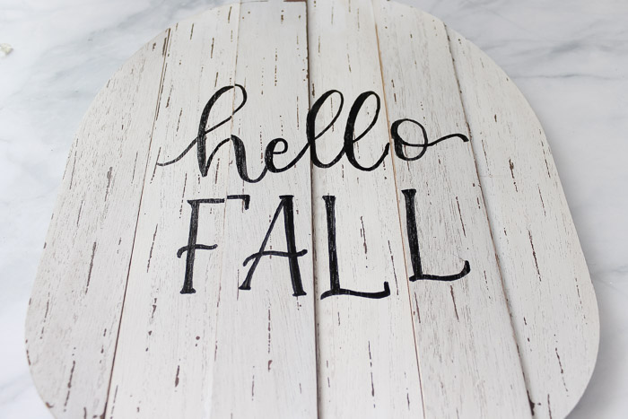 white wooden pumpkin with hello fall written on it