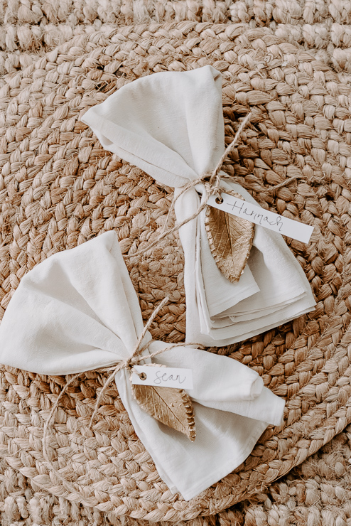 napkins tied with gold clay leaves and name tags