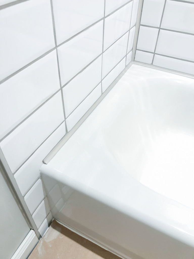 close up of schluter greige profiles around tub and along edge of tile