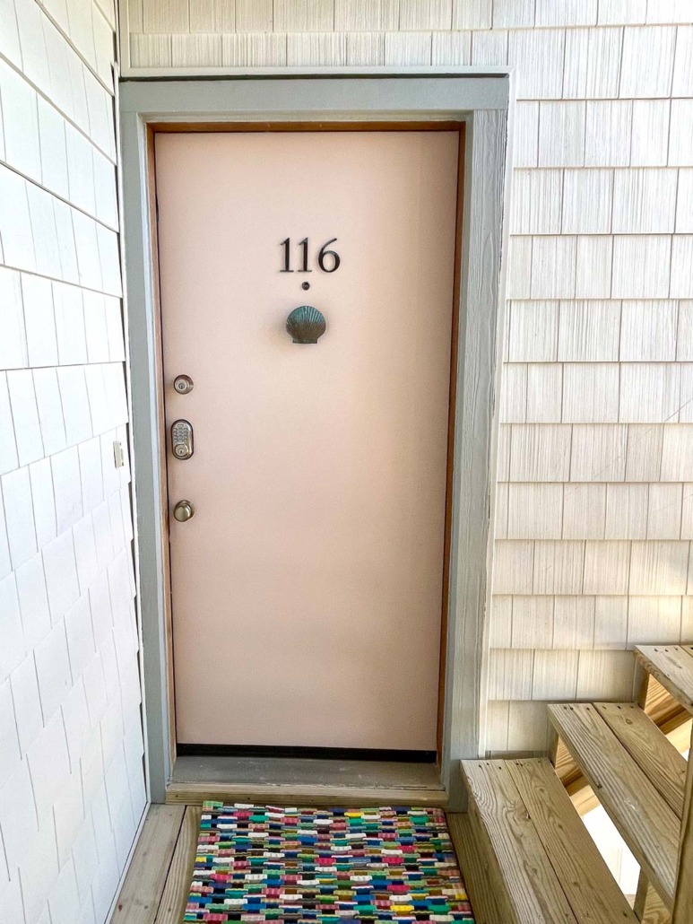 Abalone Shell by Sherwin Williams - cute muted pink condo door with patina shell knocker