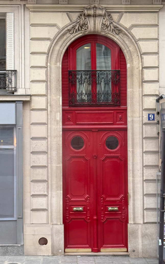 Quite Red by Valspar. Tall double red doors with wrought iron detail on arched doorway opening