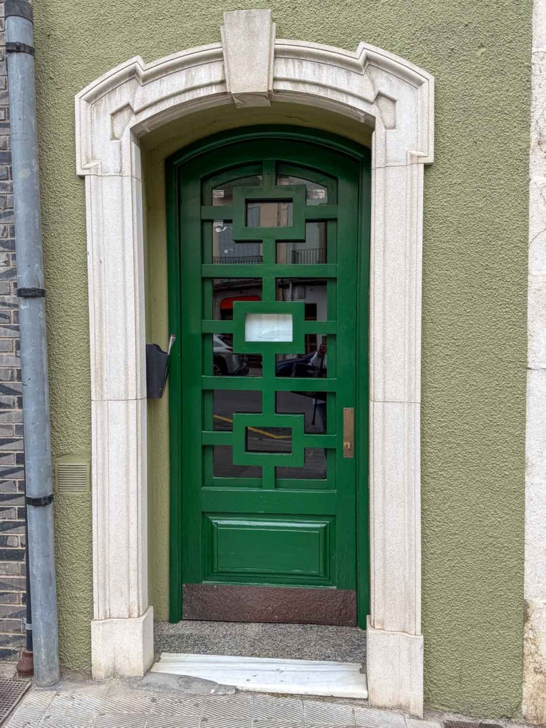 Vegas Green by Valspar arched emerald or Kelly green door with ornate windows and green stucco siding, white trim